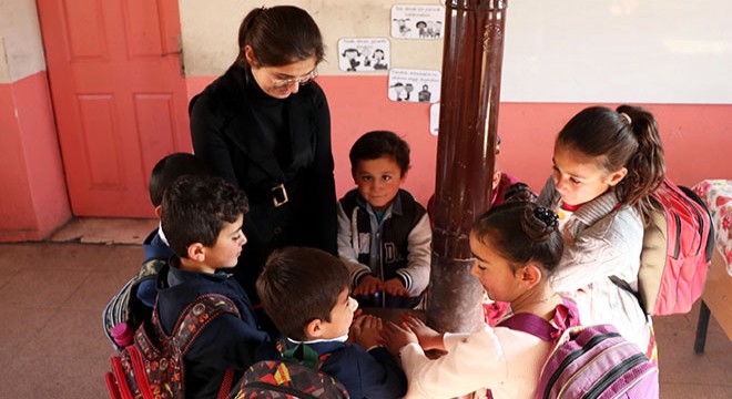 Öğrencileri için odun kırıp, soba yakıyor