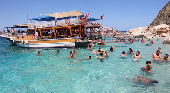 Tatilciler tekne turunda Antalya'nın cennet koylarını görüp, serinliyor